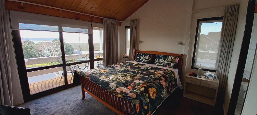 奥克兰Auckland Beachview Homestay with free Netflix, Parking的一间卧室设有一张床和一个大窗户