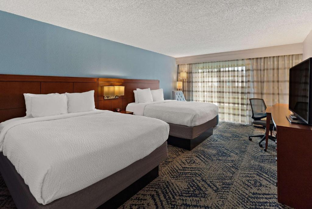 斯帕坦堡Best Western Spartanburg Northwest的酒店客房设有两张床、一张桌子和一台电视。
