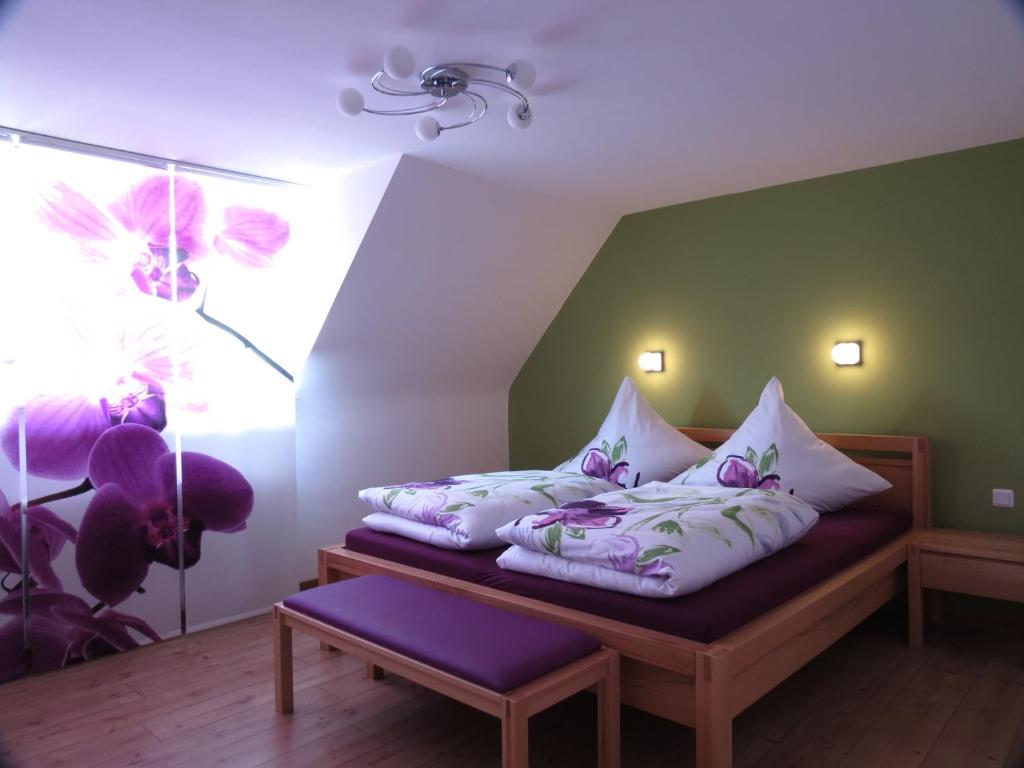 于伯林根Ferienoase ENGEL的一间卧室配有一张带紫色和白色枕头的床