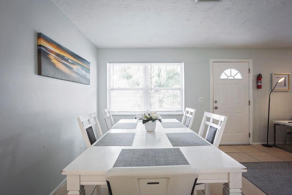 克利尔沃特Sunny Shores Retreat 1的一间配备有白色桌椅的用餐室