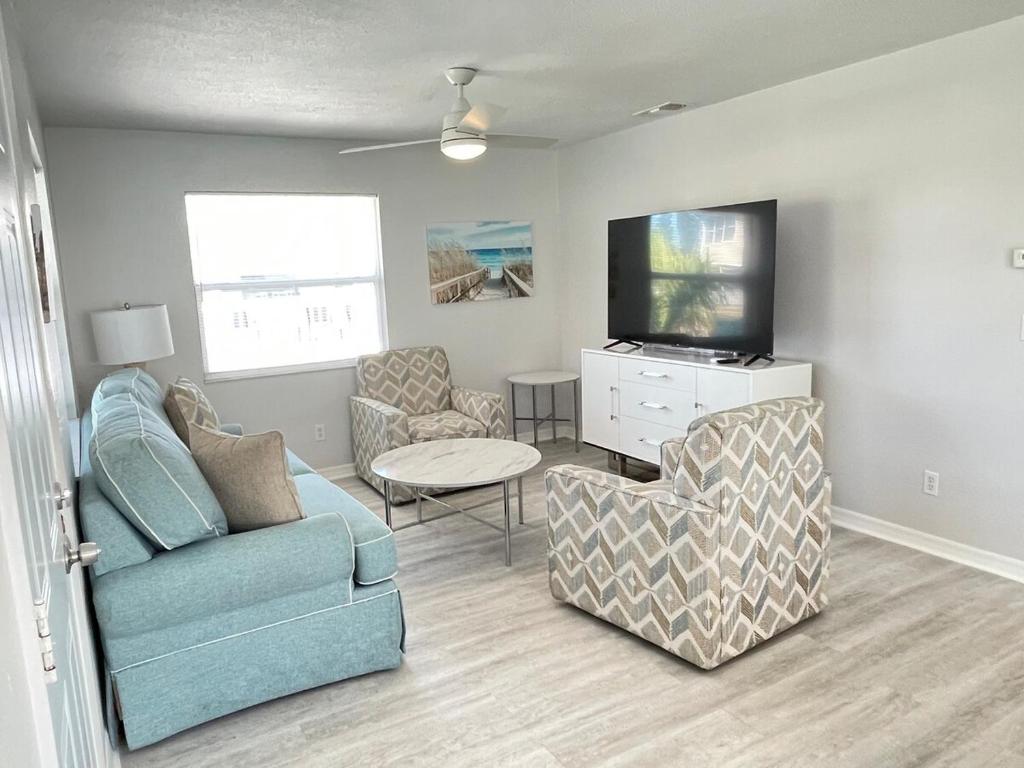 克利尔沃特Beachside Getaway West的客厅配有沙发、椅子和电视