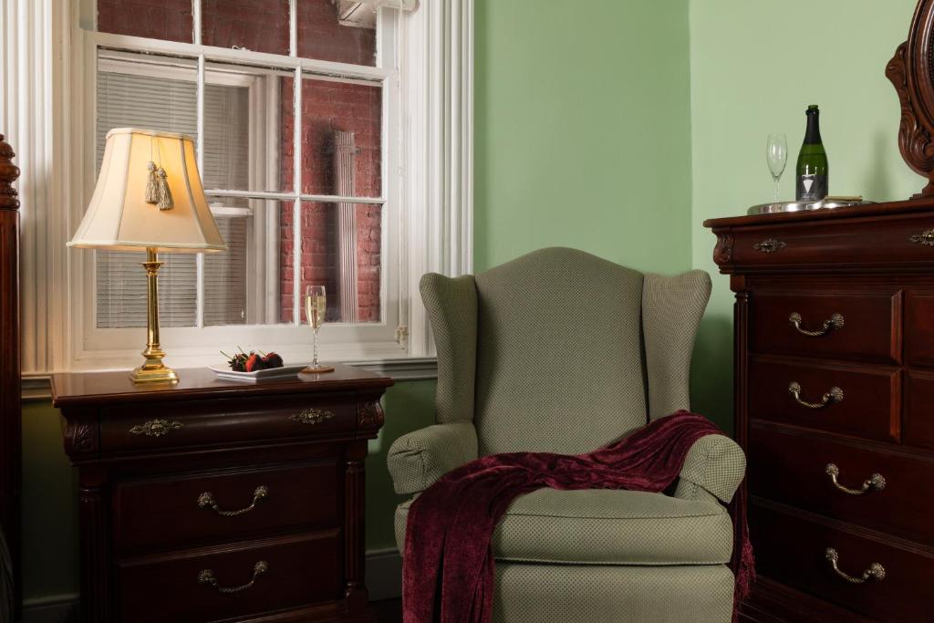 卡莱尔Carlisle House Bed and Breakfast的一间卧室配有椅子、一盏灯和梳妆台