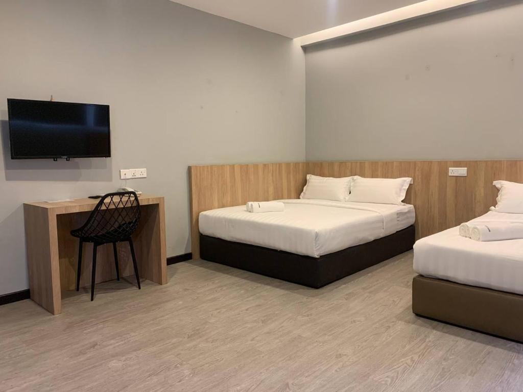 哥打京那巴鲁The Daily Hotel的客房设有两张床和一台平面电视。