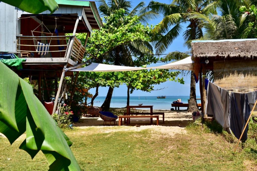 高龙撒冷岛柬埔寨海滨之家旅馆的一个带桌子和长凳的房子,享有海景