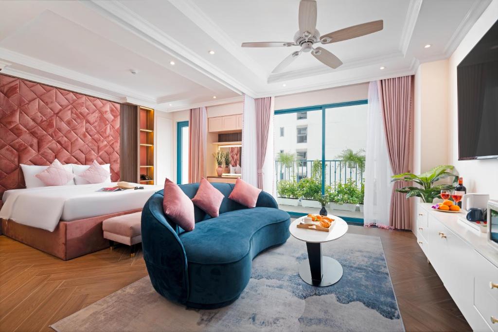 芽庄Pavillon Boutique Hotel & Apartment Nha Trang的酒店客房,配有床和蓝色的沙发
