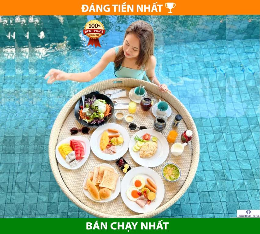 岘港Ngọc Bích Hotel Da Nang的坐在桌边的年轻女孩,在游泳池里吃点东西