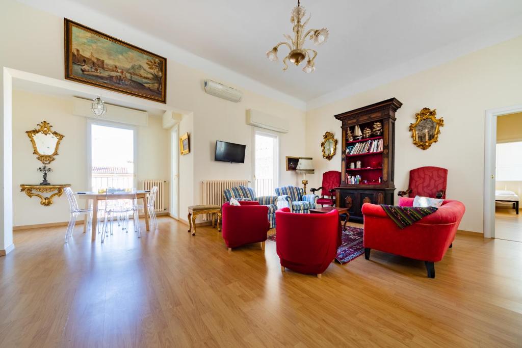 博洛尼亚GetTheKey Attico delle Torri的客厅配有红色椅子和桌子