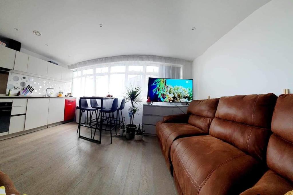 伯恩茅斯Luxury 1 bed apartment-sea view的一间带棕色沙发的客厅和一间厨房