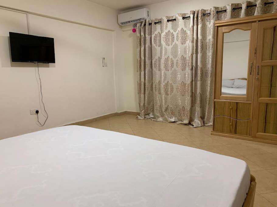 库马西Cozy One Bedroom Apartment near KNUST & CCC的一间卧室配有一张床、一台电视和一个窗口