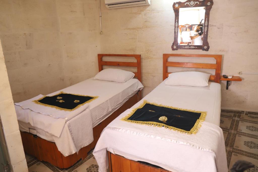 ŞahinbeyLÜTFÜ BEY KONAĞI的配有镜子的客房内的两张床