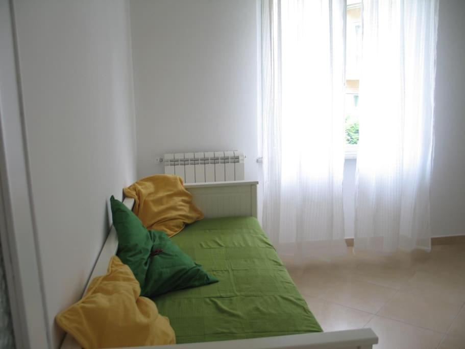 菲纳莱利古雷Apartment with private Garden的一张绿色沙发,里面配有两个枕头