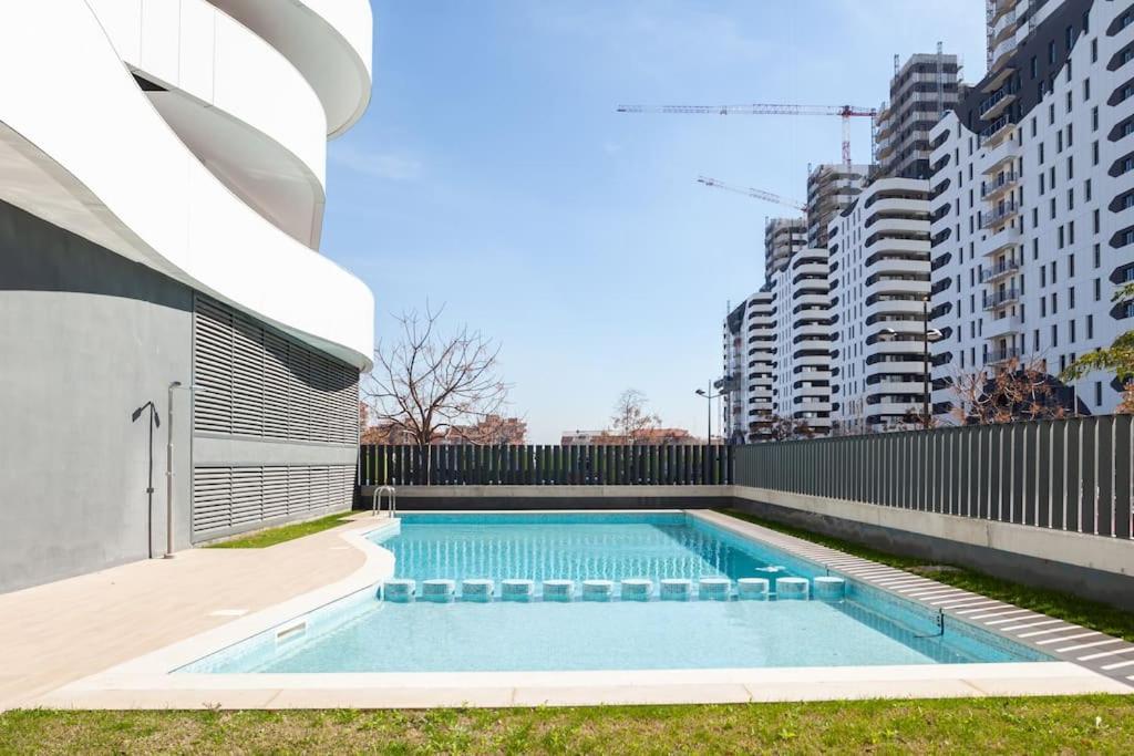 瓦伦西亚Precioso apartamento en residencial con piscina的一座高楼前的游泳池