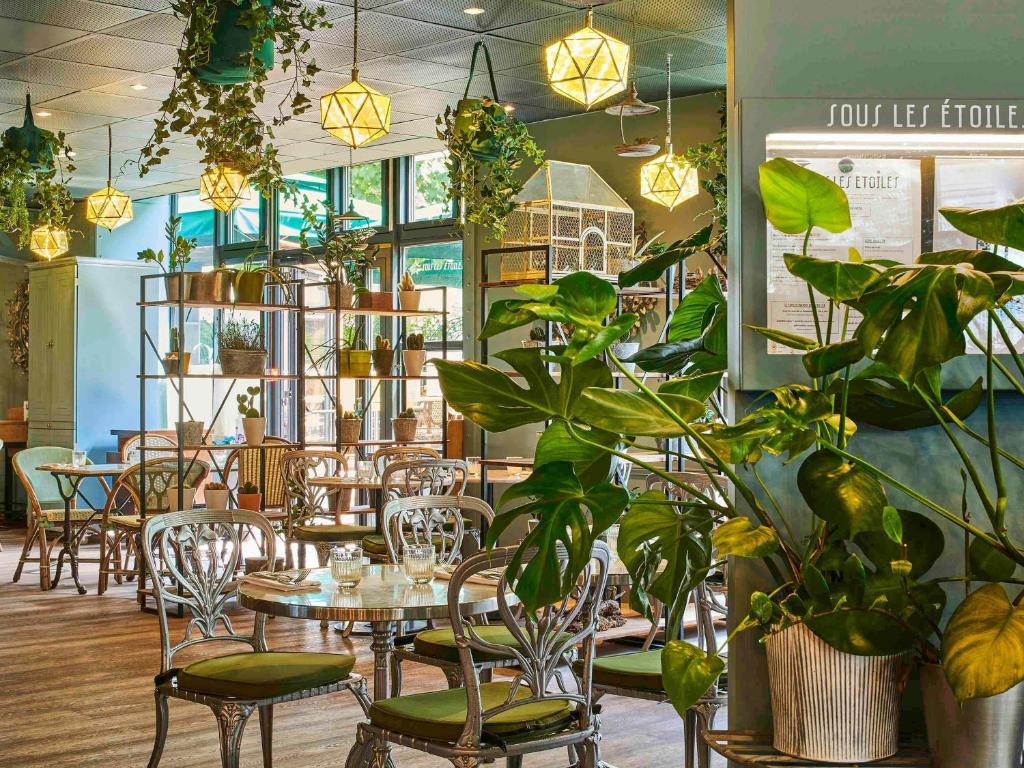 巴黎巴黎巴士底歌剧院宜必思酒店的一间设有桌椅和盆栽的餐厅