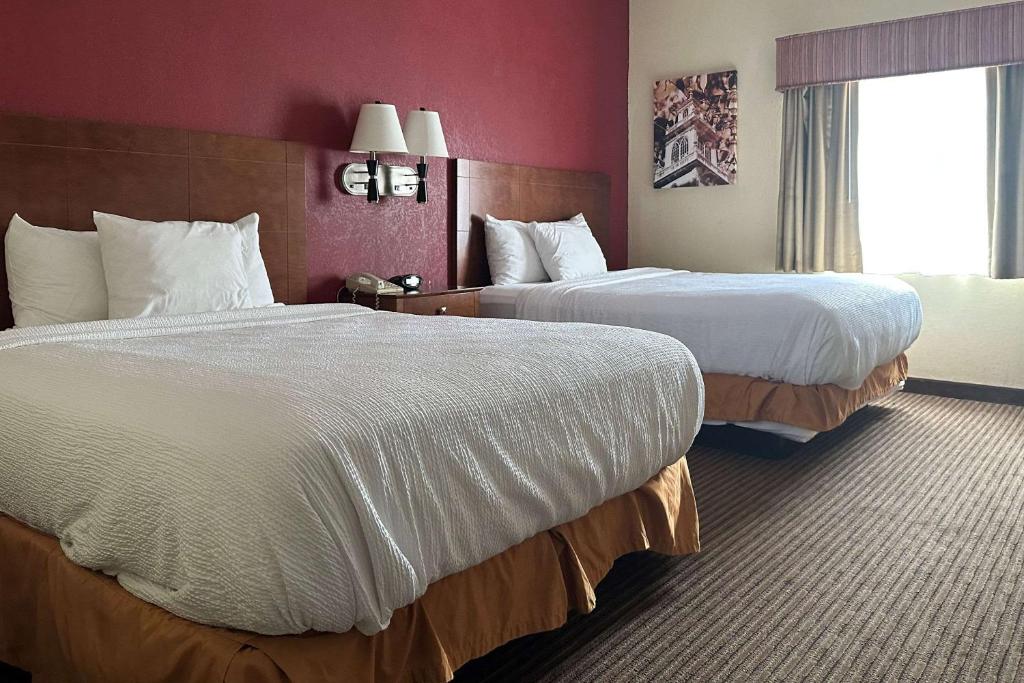 皮克林Executive Suites的酒店客房设有两张床和窗户。