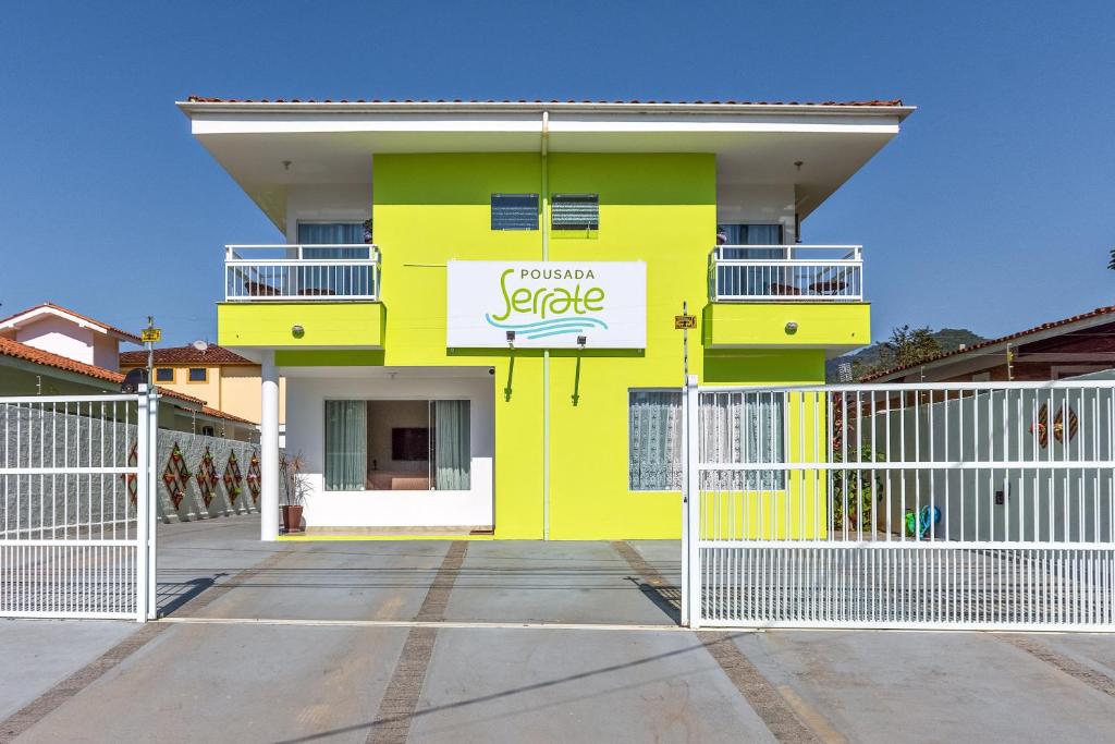 乌巴图巴Pousada Serrate的黄色的建筑,上面有标志