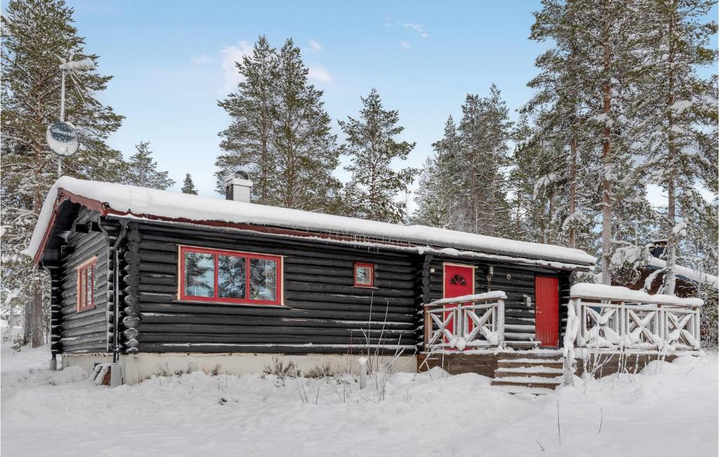 萨伦3 Bedroom Amazing Home In Slen的雪中带红门的小木屋