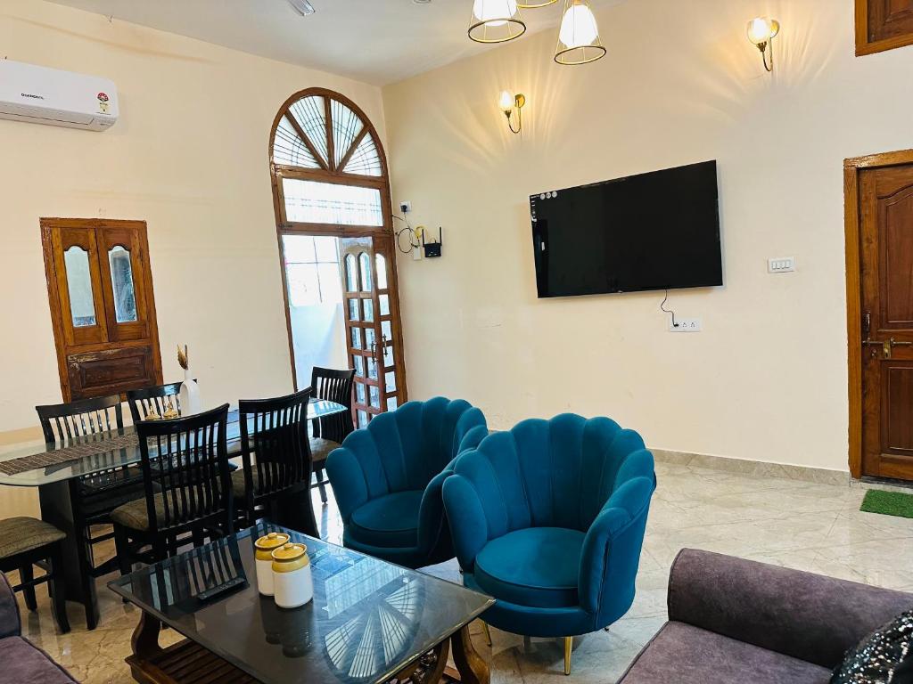 瓦拉纳西Bluetique的客厅配有蓝色椅子和电视