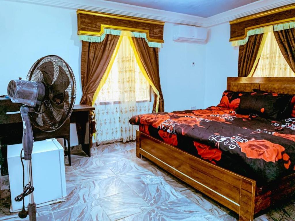 阿布贾Select Elegant 3 Rooms 3 sized king-bed @ Abuja FCT的一间卧室配有一张床和一个风扇。