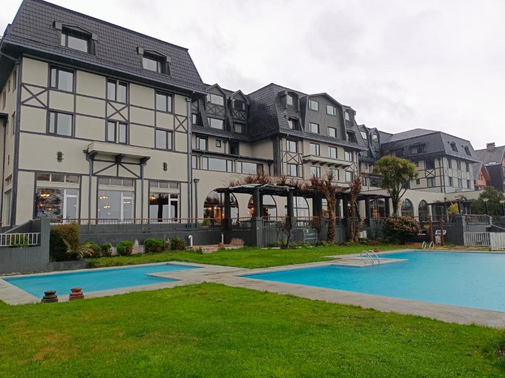 普孔Hotel Enjoy Pucon的一座大房子,前面设有一个游泳池