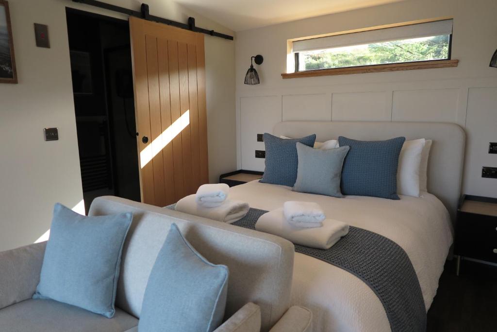 SconserAngusfield Cabins的一间卧室配有一张带蓝白色枕头的大床