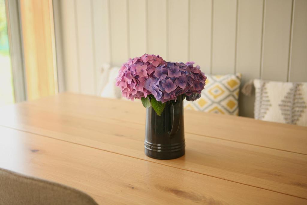 科克Ocean Breeze的花瓶,花朵盛满紫色,坐在桌子上