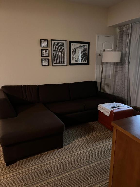 米西索加Queen bed available的客厅配有黑色沙发和搁脚凳