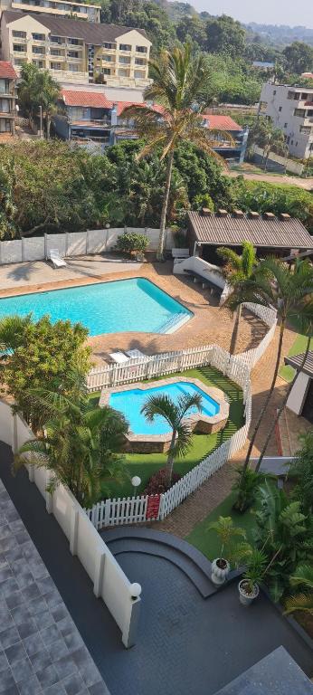马盖特Santana holiday resort 803的享有棕榈树和建筑的游泳池的顶部景致