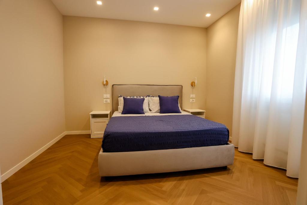 雷焦卡拉布里亚T&L-Home的一间卧室配有一张带蓝色棉被的床