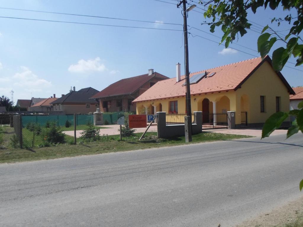 RajkaKiserdő Vendégház的街上有红色屋顶的黄色房子