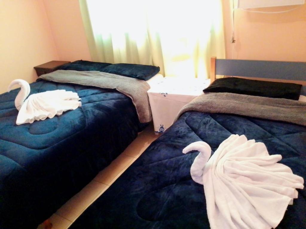 波萨达斯Costa Posadas的卧室内的两张床和天鹅