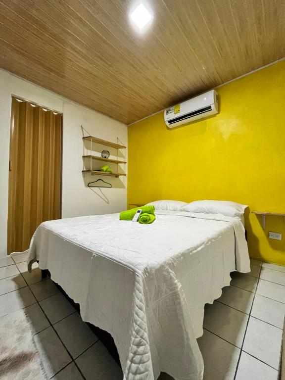 戈尔菲托Cabinas Golfito的一间卧室设有一张黄色墙壁的大床