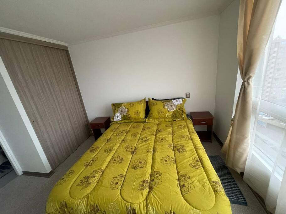 伊基克Excelente Departamento 2 habitaciones 2 baños Iquique的卧室内的一张床位,配有黄色的床罩