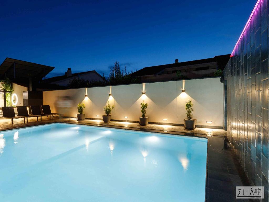 阿卡斯Villa Eliá的房屋一侧带灯光的游泳池