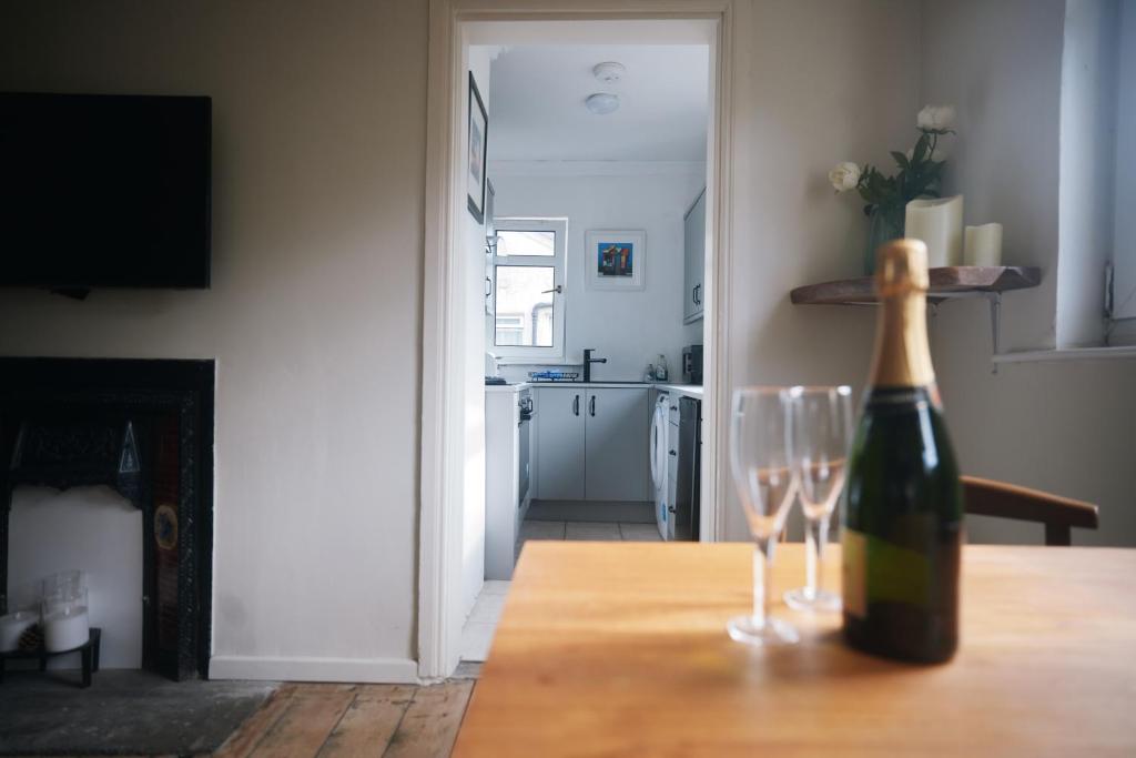 亚历山德里亚Loch Lomond Apartment的一张桌子上摆放着一瓶葡萄酒和两杯酒杯