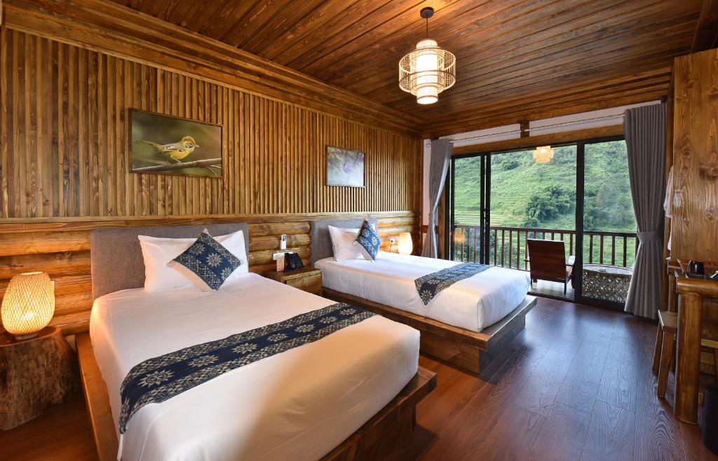 萨帕Maison de Lao Chai的一间卧室设有两张床和大窗户