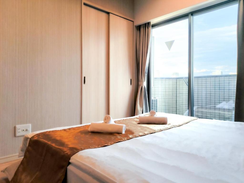 大阪Ostay Vermillion Namba的一间卧室配有一张大床和两条毛巾