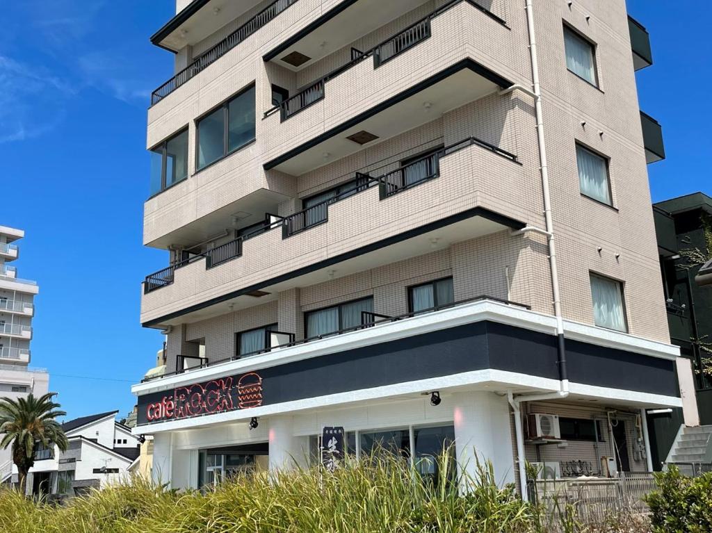 南知多Support Inn Minami-Chita Annex Hamachaya的前面有标志的高楼