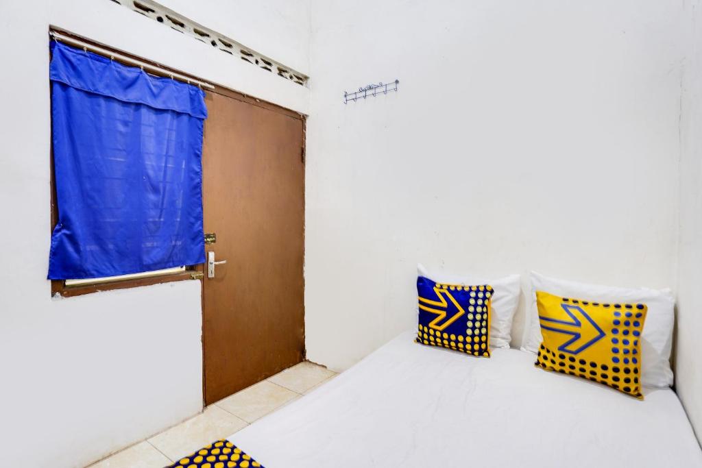 Tambak-kidulOYO Life 91893 Kost Jeje Syariah的客房配有带门和枕头的床。