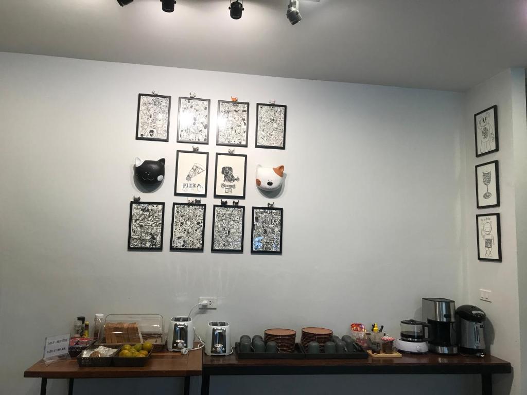 清迈Chern Chiangmai Boutique的一张白色的墙壁,上面有照片,还有桌子