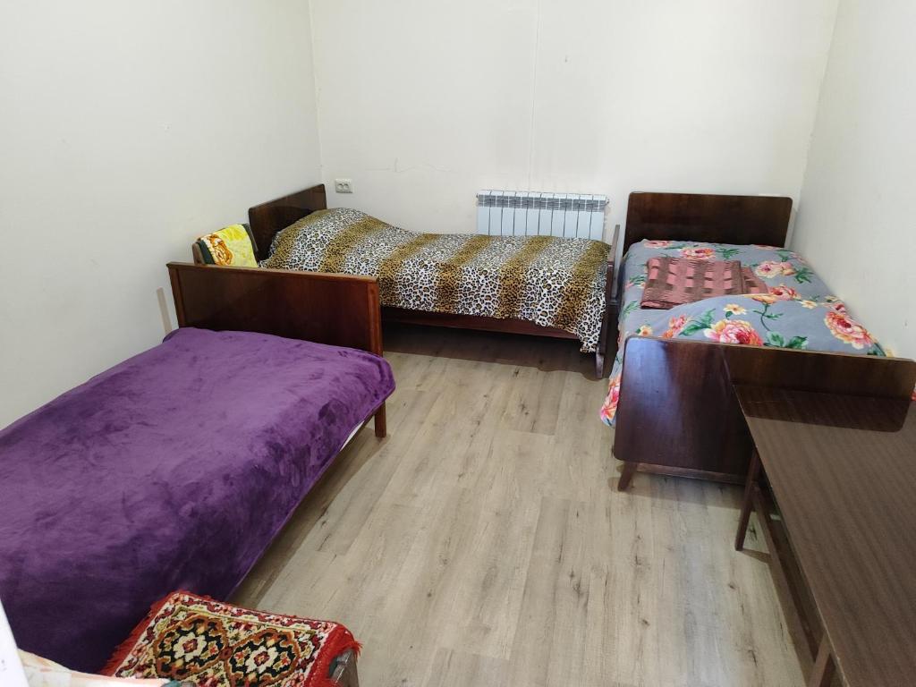 久姆里Vanand Guest House的客房设有两张床,铺有木地板。
