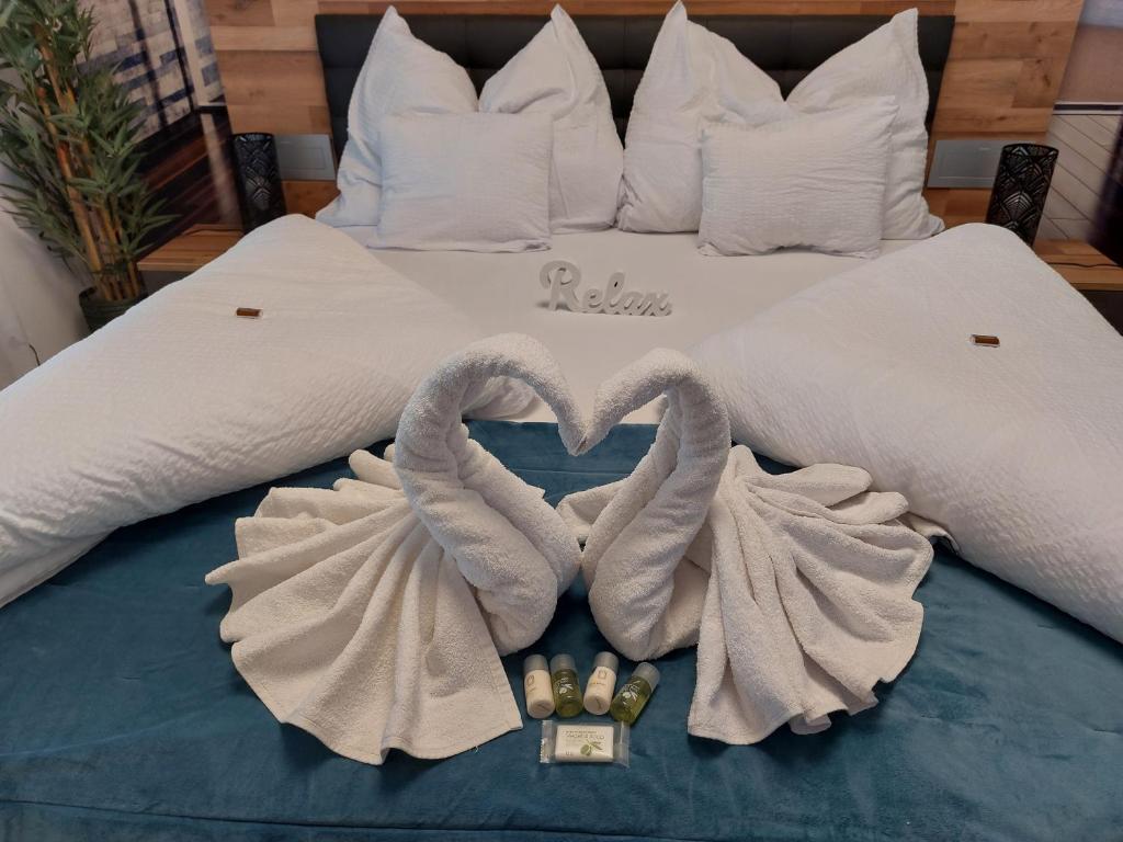 凯奇凯梅特Happiness Apartman的一张带两条毛巾和两条天鹅的床