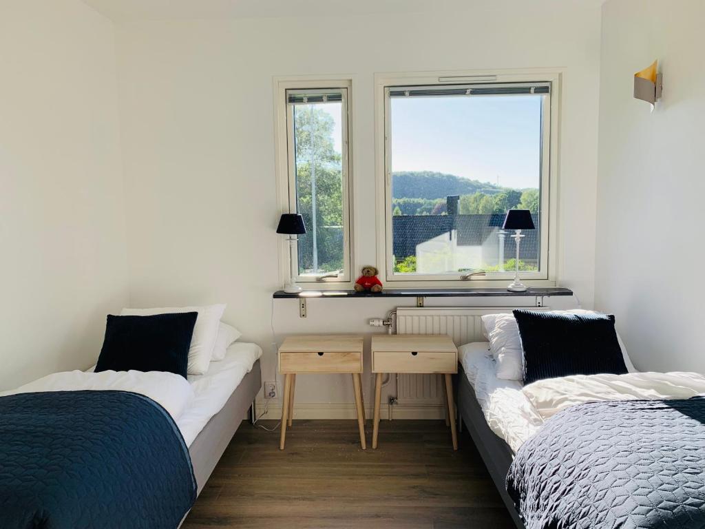 VångaLe Coq Heureux的一间卧室设有两张床、一张桌子和一个窗口。