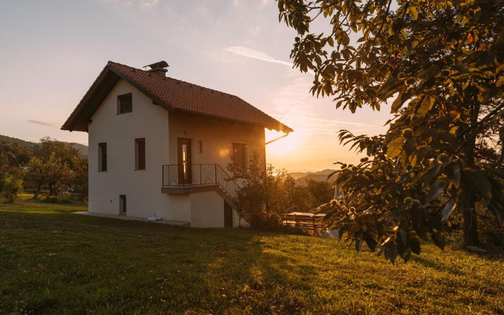 PišeceApartma Hiša na Ravnah的山丘上的房子,背景是日落