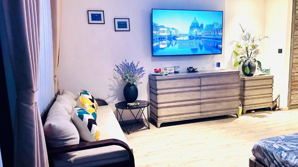 绥和市Apec Mandala Phú Yên View Biển的客厅配有沙发和墙上的电视