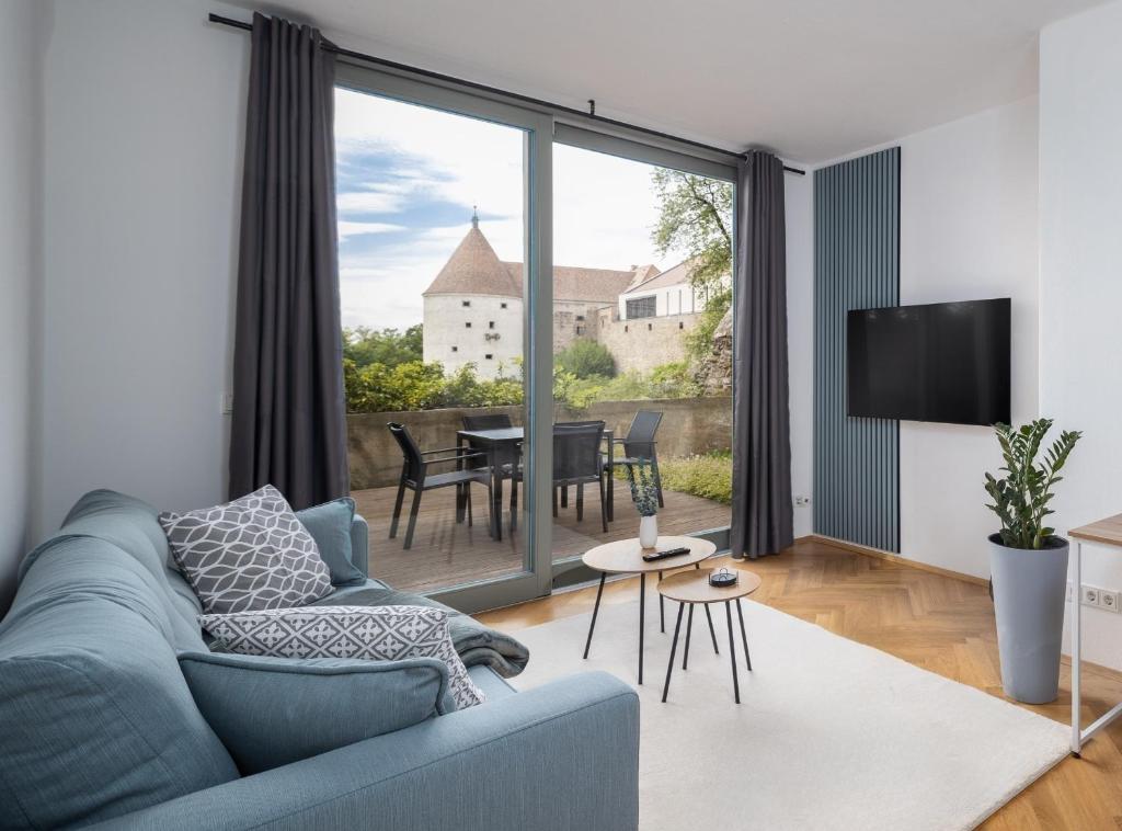 包岑CoView - Bautzen - Design Apartment in der Altstadt mit fantastischem Ausblick的客厅配有蓝色的沙发和电视