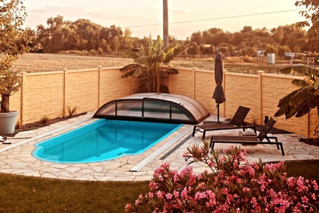 路德斯塔德·威特比Pool, Sauna und Blick ins Grüne的一个带椅子和遮阳伞的游泳池
