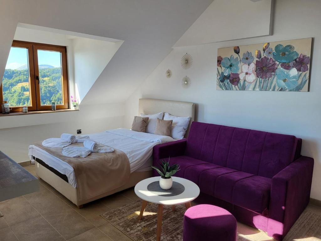 科帕奥尼克Kloudscape Apartman Milmari Resort & Spa的一张床上和一张客房内的紫色沙发