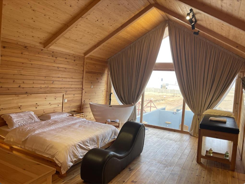 Khalij Salmanأكواخ البحيرات的一间卧室设有一张床和一个大窗户