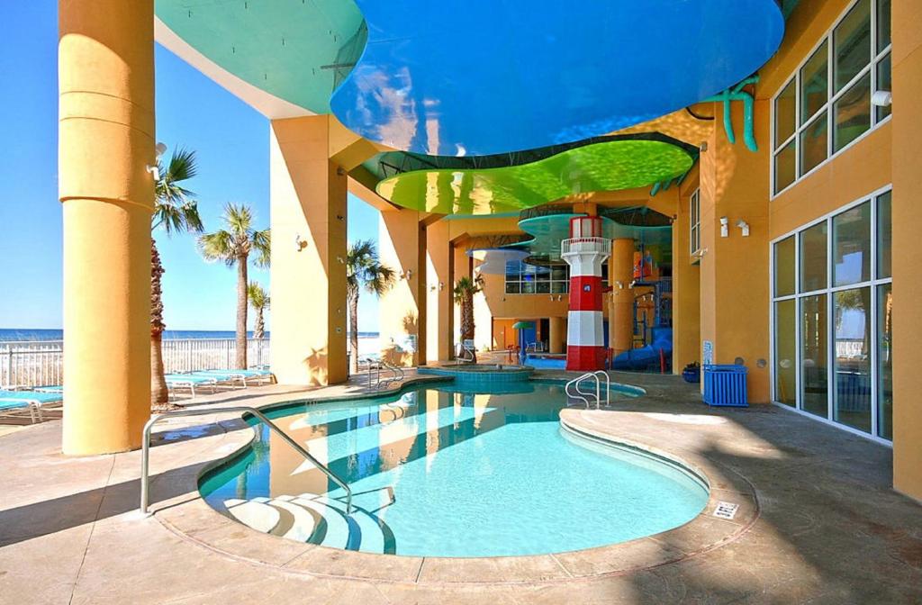 巴拿马城海滩Splash Beach Resort by Panhandle Getaways的一座带游泳池的大楼,位于大海前
