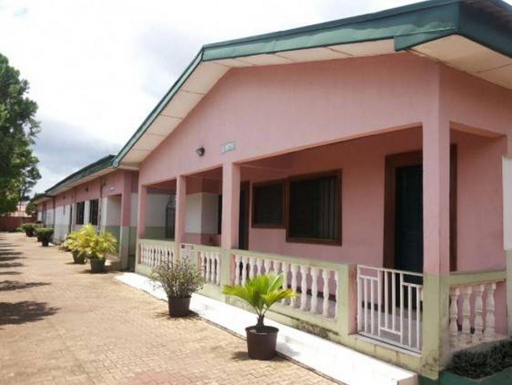 IyibaRoom in Lodge - Garentiti Apartment - Silver Room的前面有盆栽植物的粉红色房子